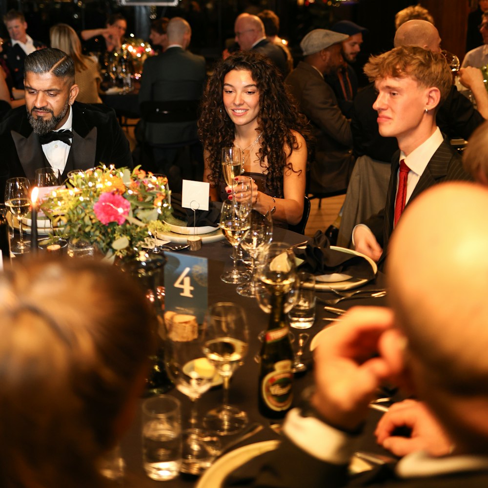 Tamu gala dinner di meja bundar berhias bunga